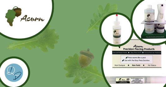 Acorn Precision Piecing Products range on a green leaf background, featuring the Easy Press Solution bottle, Easy Press Pen, and a retail display set, with the Quilt Direct logo