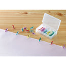 Striped fabric with pins under a sewing machine on a white background