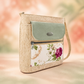 Beige textured crossbody bag with a pale green flap, zip pocket and floral print front panel.