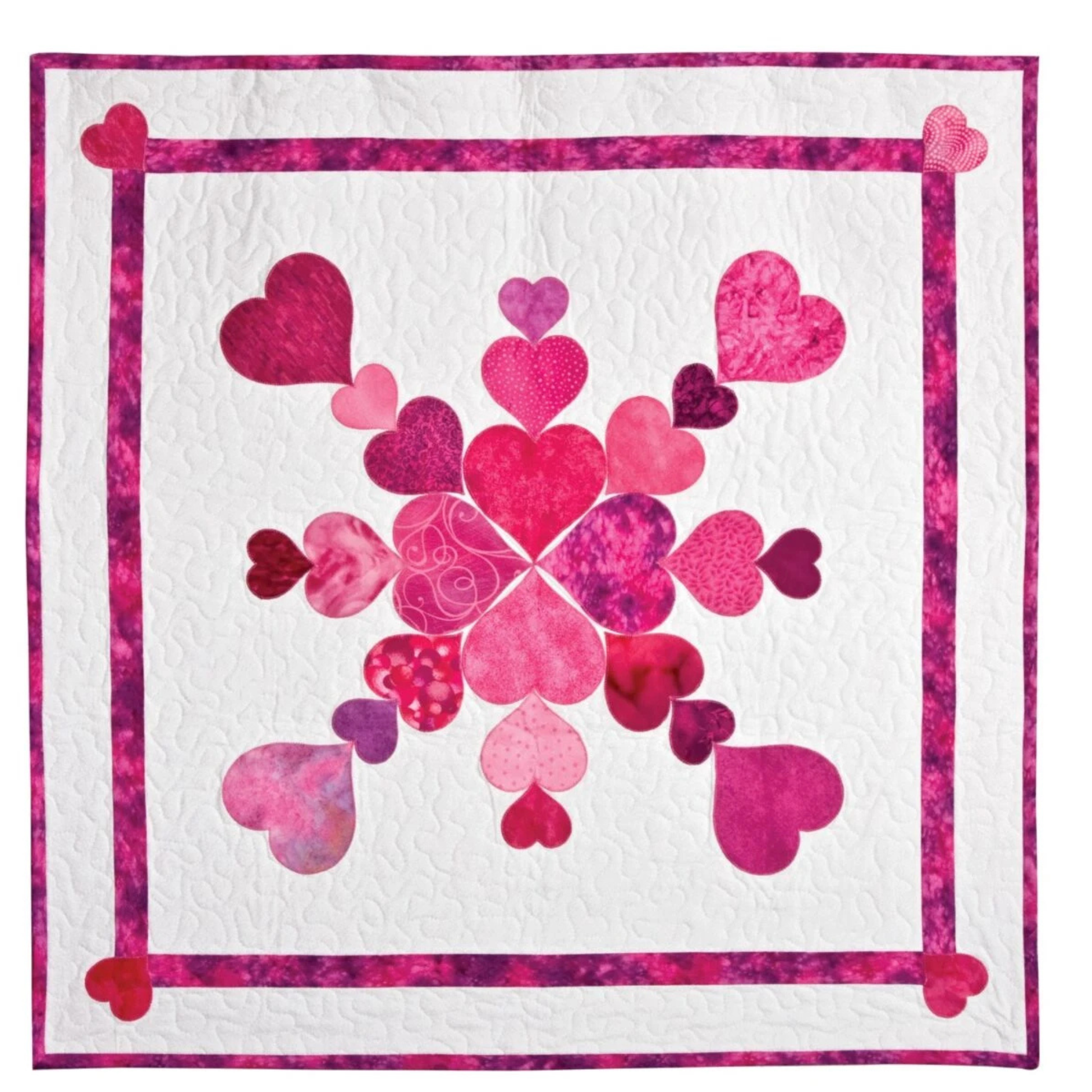 AccuQuilt GO! Heart shapes forming a pink medallion design on a white quilt with heart corners