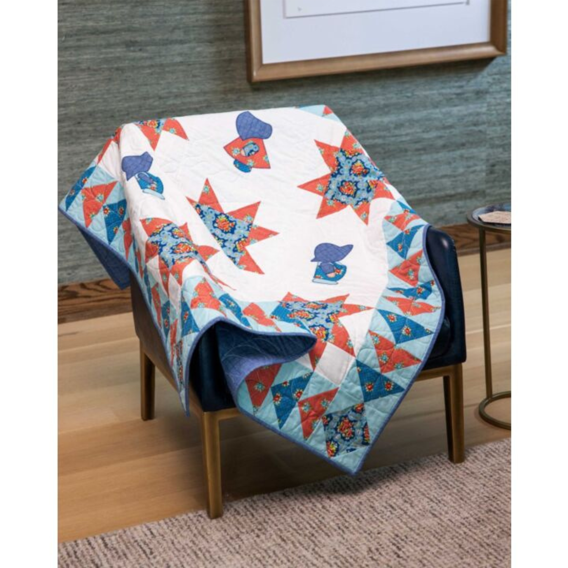 AccuQuilt GO! Overall Sam star quilt draped over a navy armchair