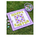 Happy Easter quilt with a purple and olive star block, styled on grass with an egg basket