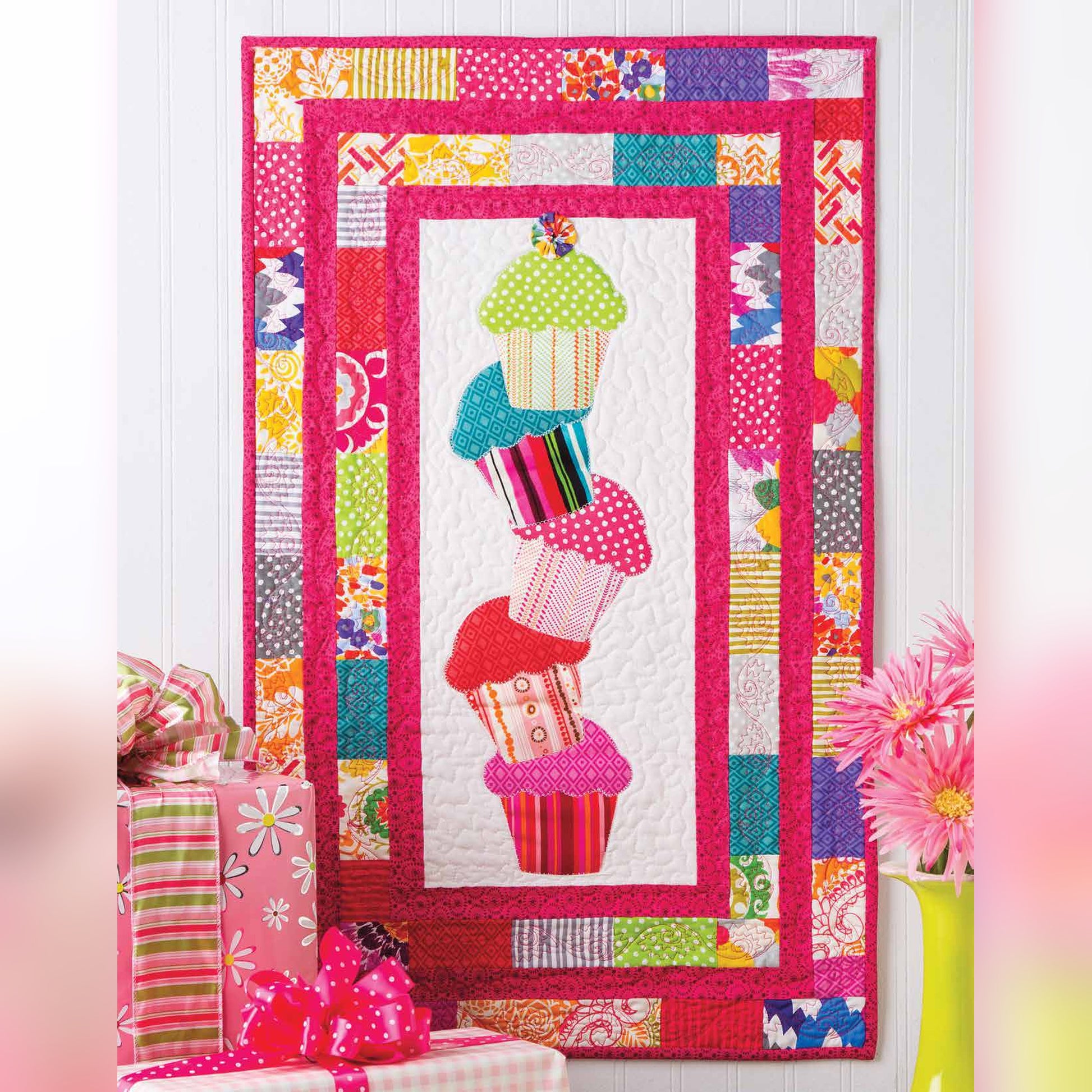 AccuQuilt GO! Cupcake tower wall hanging with five stacked cupcakes on a scrappy pink border