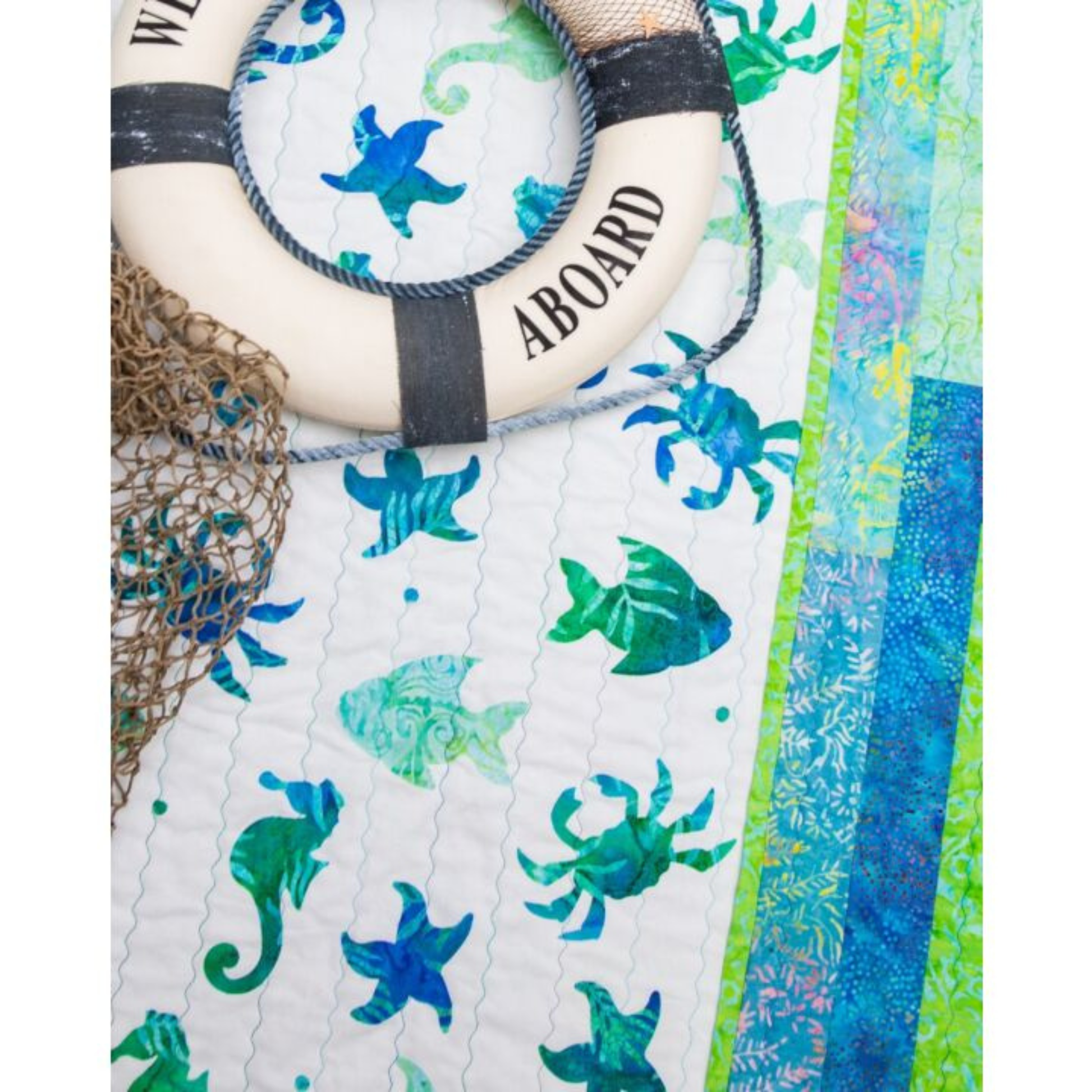 AccuQuilt GO! Sea Life Medley quilt close-up styled with a Welcome Aboard life ring and fishing net