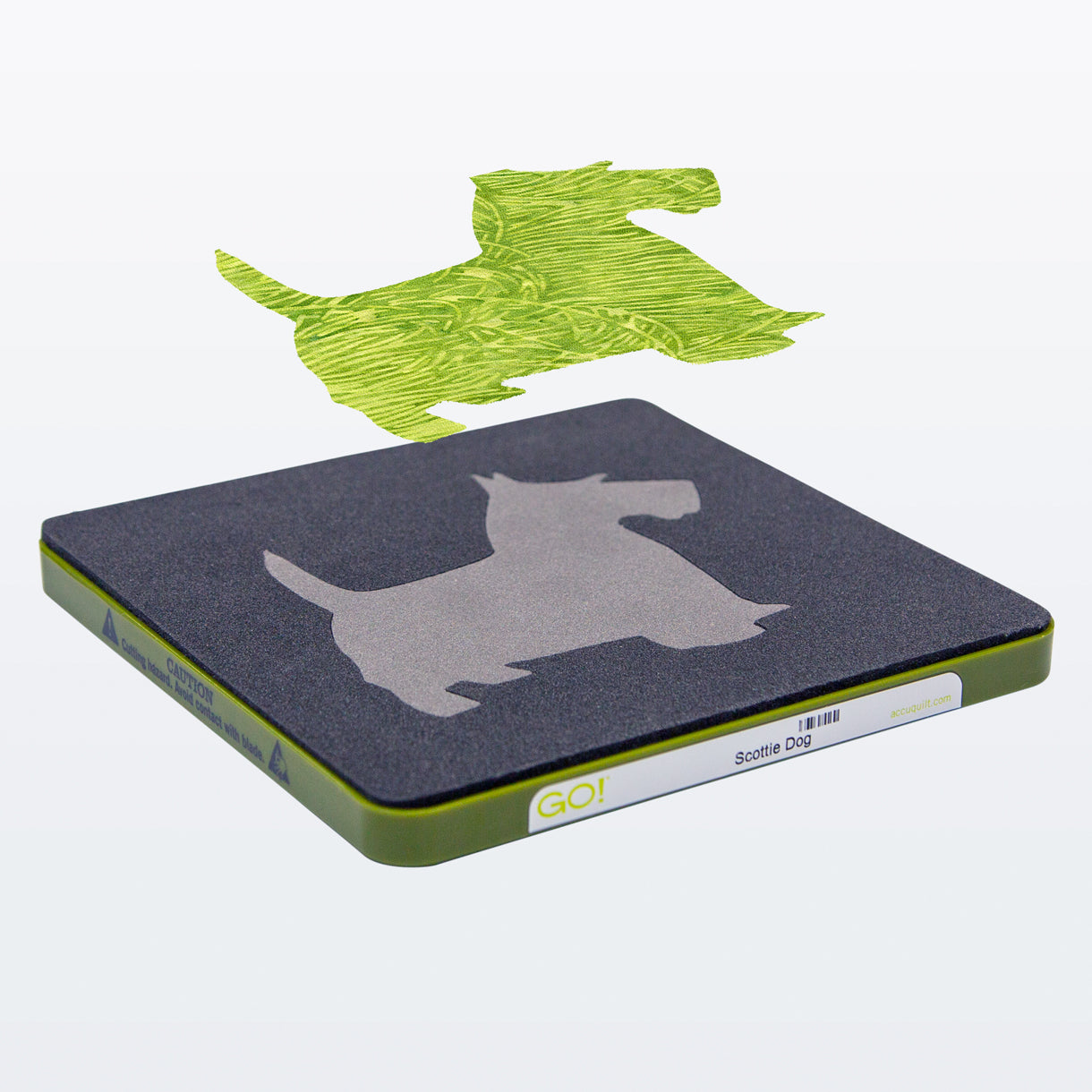 AccuQuilt GO! Scottie Dog die at an angle with a green batik dog shape cut and lifted above it