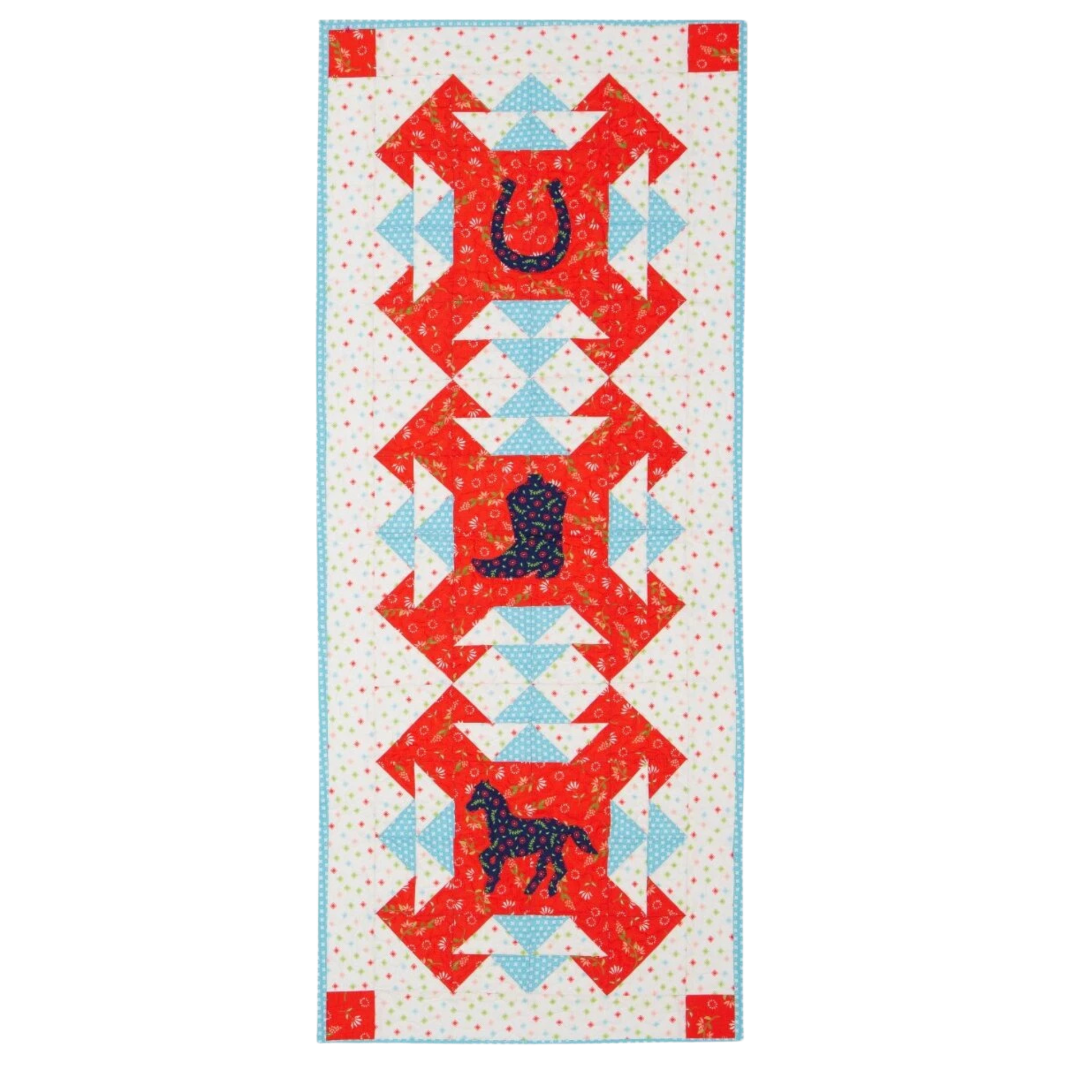 AccuQuilt GO! Western Medley horseshoe, boot and horse in navy floral fabric on a red table runner
