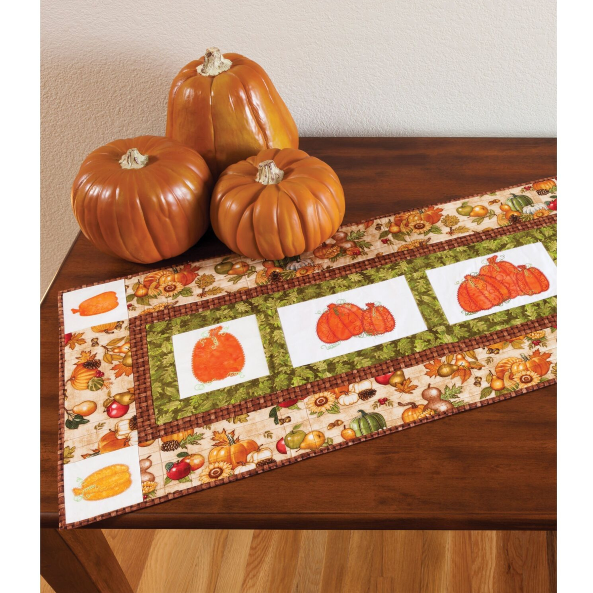 AccuQuilt GO! Pumpkins harvest table runner styled with real pumpkins on a wooden table