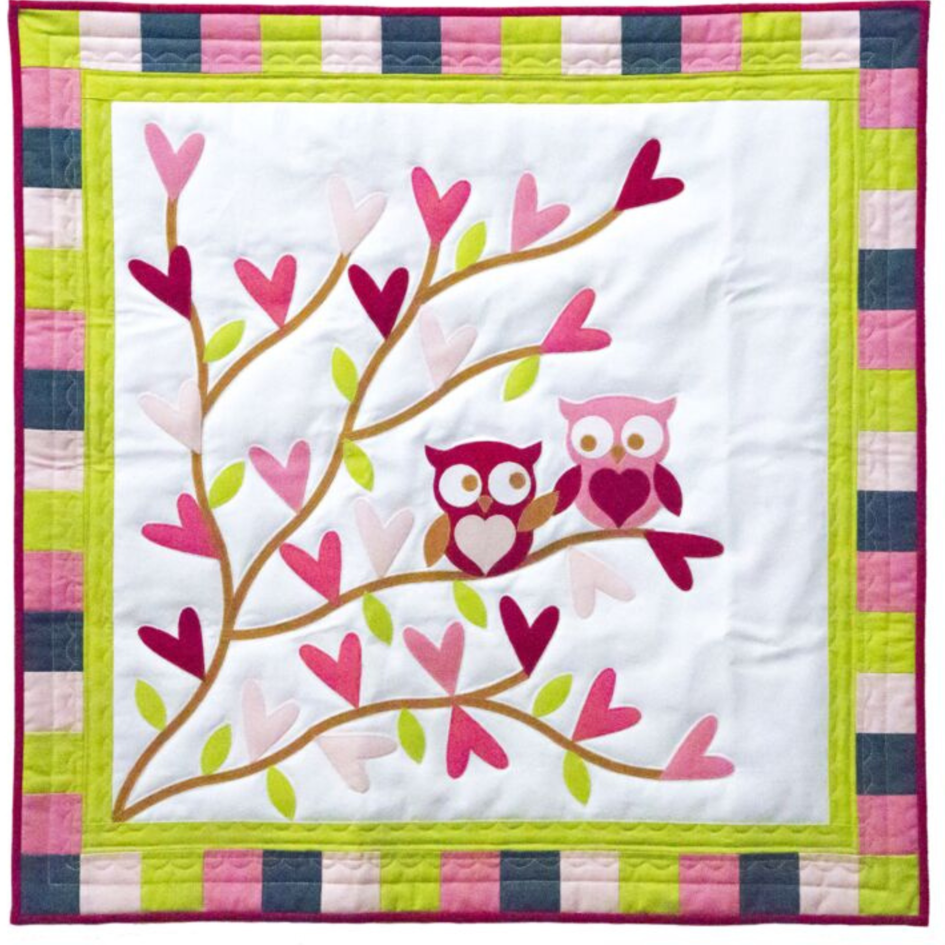 AccuQuilt GO! Stems & Leaves branch with heart blooms and two owls, on a checkered border quilt