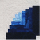 ie - close-up of curved log cabin block corner in navy and sky blue batik fabrics with feather quilting detail