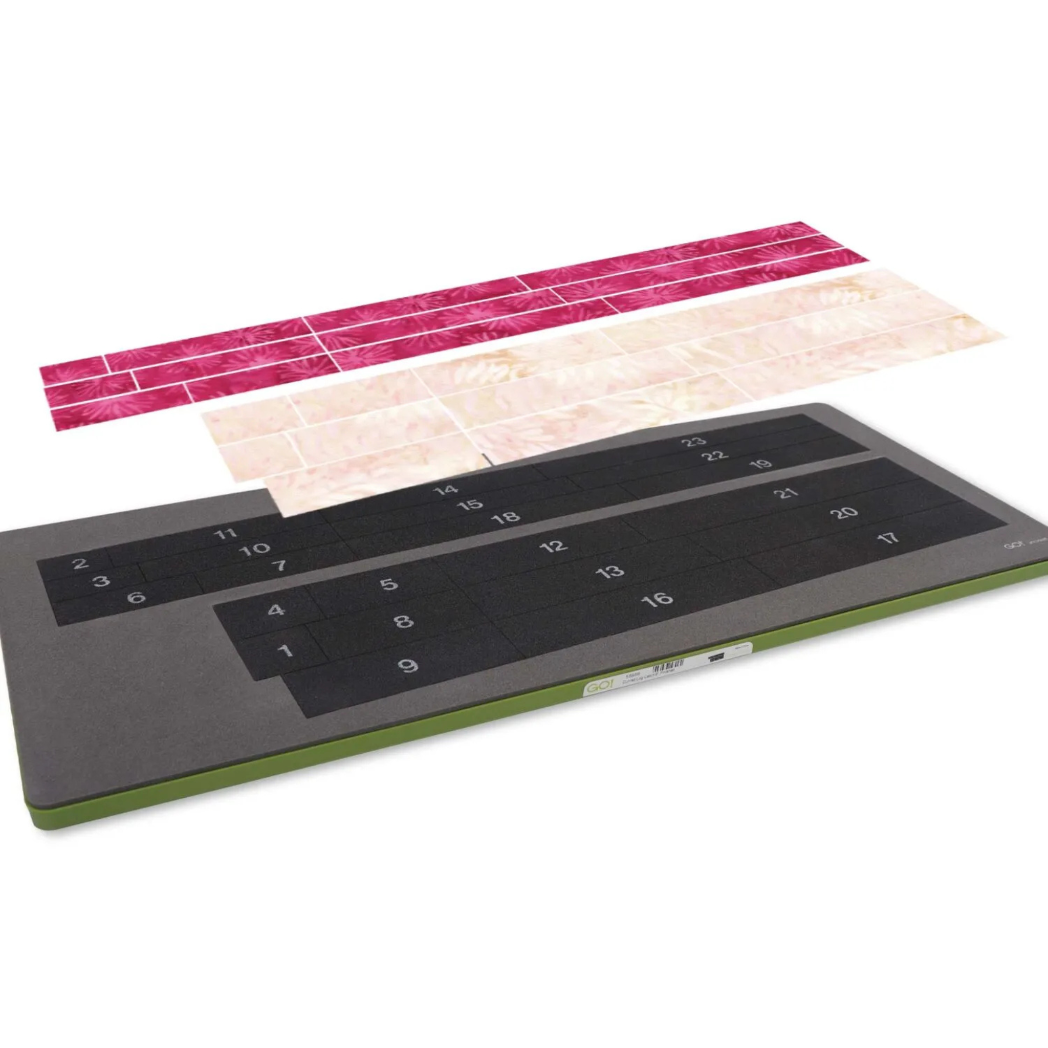 AccuQuilt GO! Curved Log Cabin 9" Block On Board Die - Block On Board die shown with pre-cut fabric strips in pink and cream ready for cutting