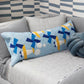 Long quilted bench pillow with blue Airplane blocks, yellow accents and white clouds on a grey sofa