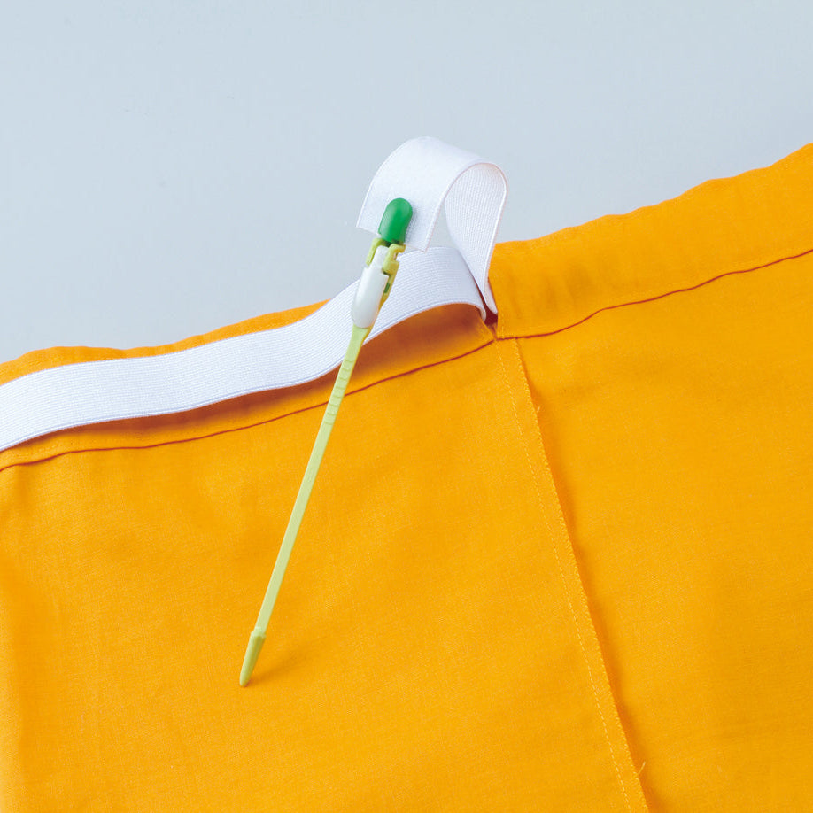 Yellow shorts with a white elastic being threaded through the waistband with Clp'n Glide bodkin