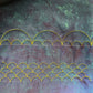 Clamshell background quilting and combined-size scalloped borders stitched in yellow thread on multicoloured fabric