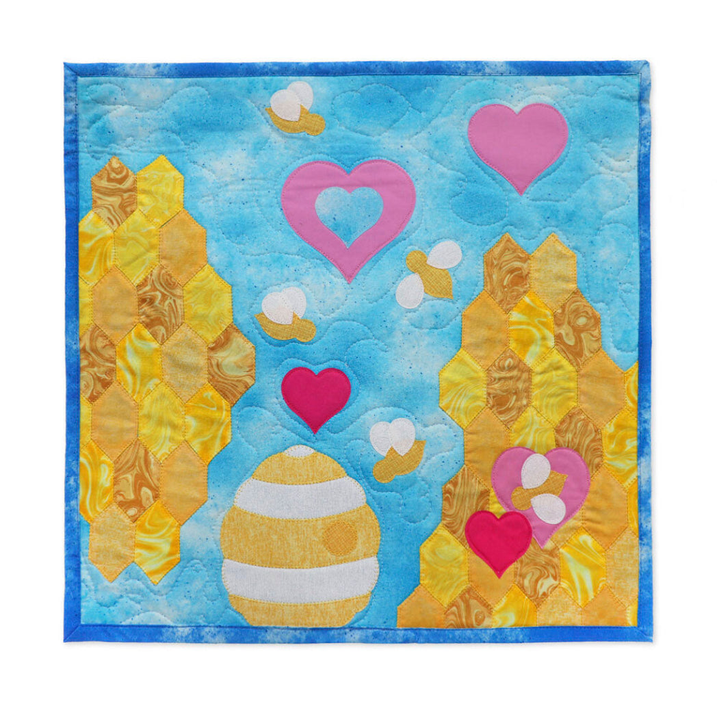 Aqua quilted cushion cover featuring white and gold honeycomb EPP flower blocks made with AccuQuilt GO! Honeycomb die