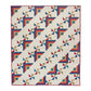 Patchwork throw quilt with red, blue and gold Log Cabin corners and multicoloured pinwheel motifs on a cream background.