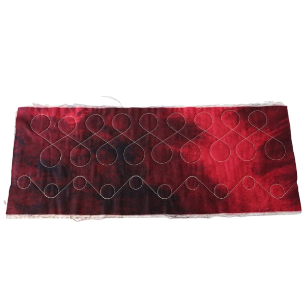 Infinity loops and alternating high-and-low circle borders stitched on red patterned fabric