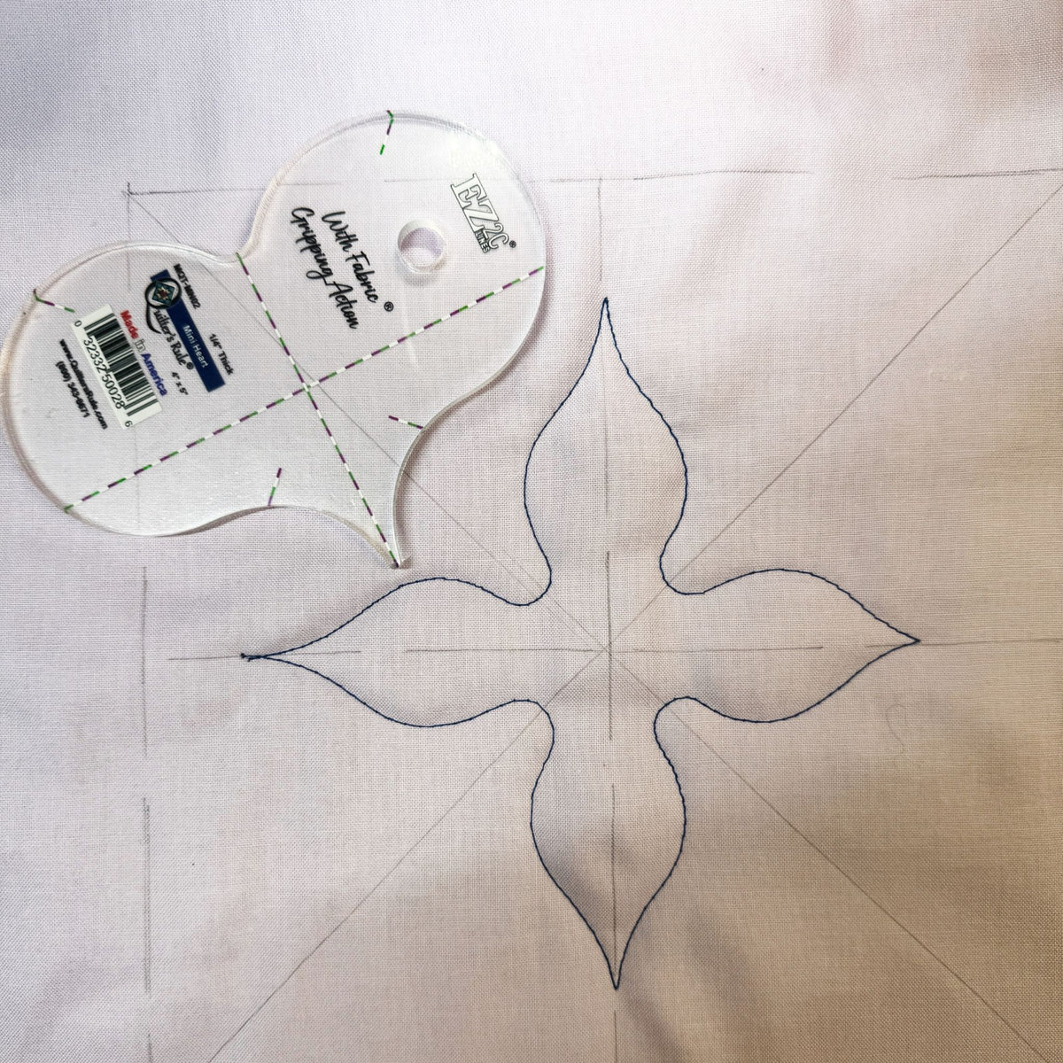 Mini Heart Gripping Action template beside a four-point quilting motif on white fabric