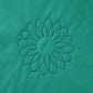 Overlapping sunflower quilting motifs forming a fuller flower in dark thread on green fabric