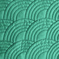 Overlapping nested arc quilting patterns with wider spacing stitched on green fabric