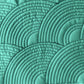 Closely spaced nested arc quilting patterns stitched on green fabric