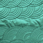 Two bands of nested arc quilting patterns with different spacing stitched on green fabric
