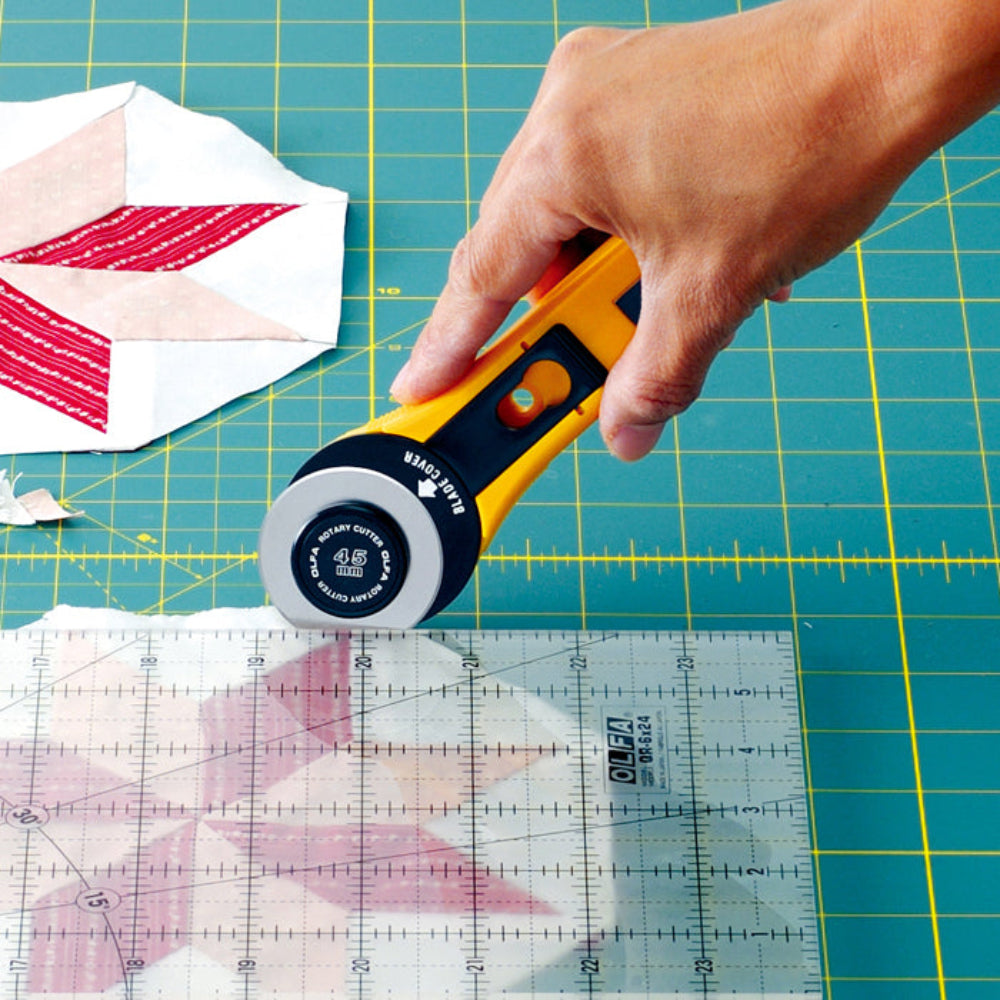 Genuine Olfa 45mm Rotary Cutter Original Handle - Blade Cover and Handle Detail - in use trimming against a ruler