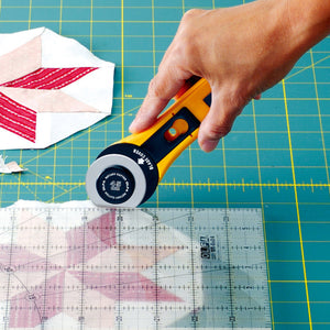 Genuine Olfa 45mm Rotary Cutter Original Handle - Blade Cover and Handle Detail - in use trimming against a ruler