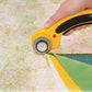 Olfa 45mm Rotary Cutter Curved Handle - In Use Cutting Fabric on a Self-Healing Mat underneath