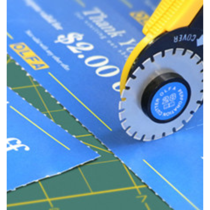Olfa 28mm Perforation Cutter in use cutting blue card on a green cutting mat
