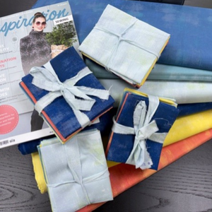 Fabric swatches in various colors with a magazine on a table