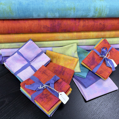 Colorful fabric swatches arranged on a dark surface