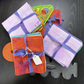 Colourful fabric swatches with a ruler quilting template on a dark surface