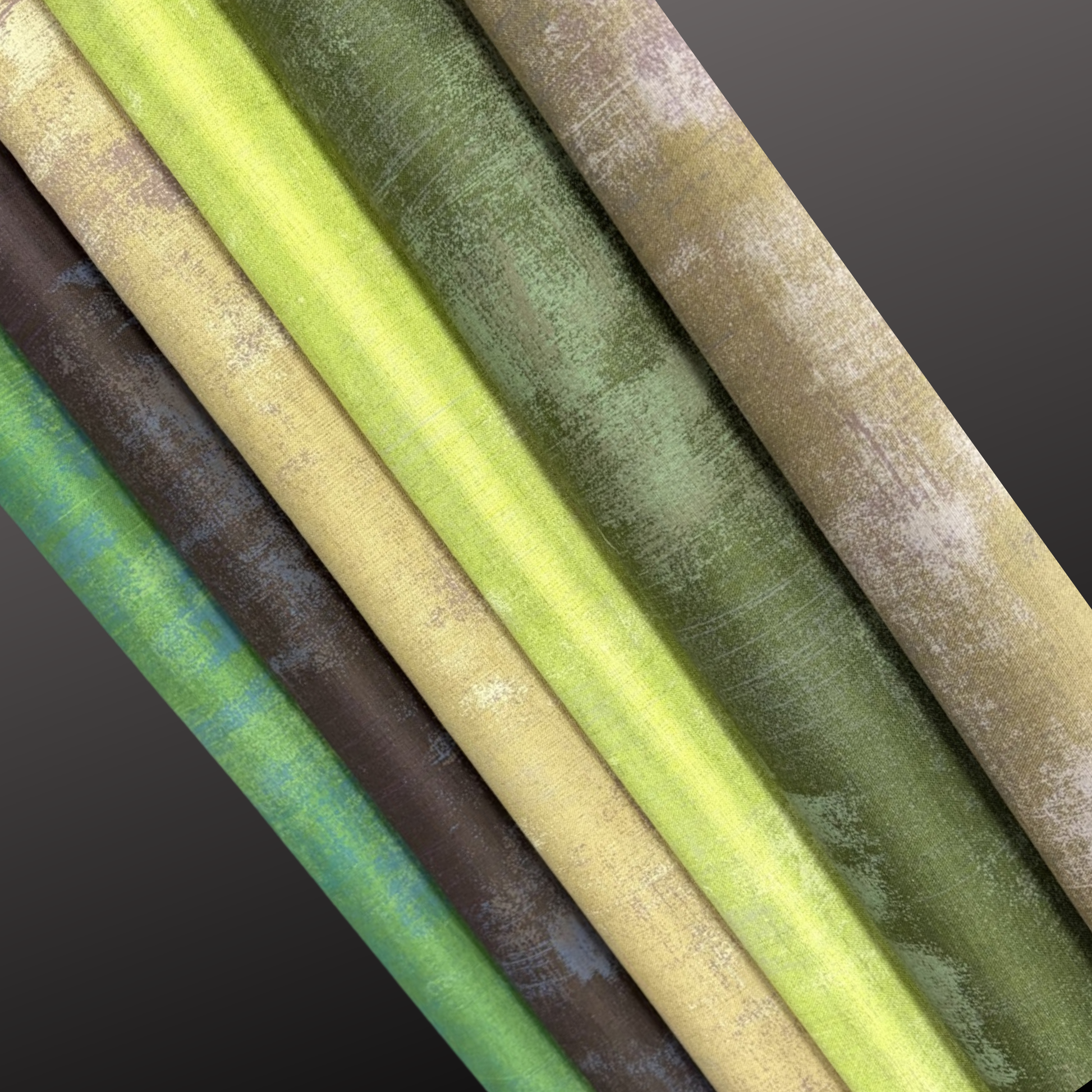 Close-up of fabric bolts in various colours on a dark background