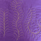 Straight and curved feather quilting designs stitched in yellow thread on purple fabric