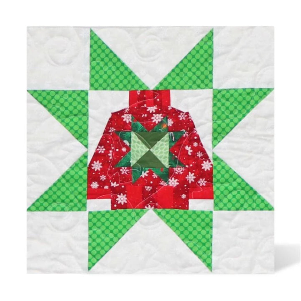 Completed AccuQuilt GO! Ugly Sweater 8" quilt block in red snowflake and green polka dot fabrics, set within a pieced star border on a white quilted background