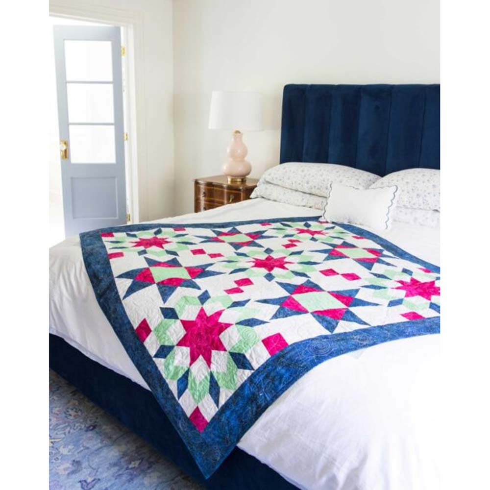 AccuQuilt GO! Carpenter's Wheel 18" Assembles Quilt in a lifestyle setting on a bed