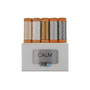 A set of five small spools of Aurifil Calm thread collection in various colors, including beige, brown, silver, gold, and blue, neatly arranged in a display box with the Aurifil logo and 'Calm' branding.